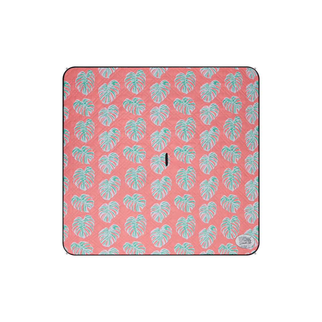 Orange 2m x 2m picnic mat featuring light green monstera leaves