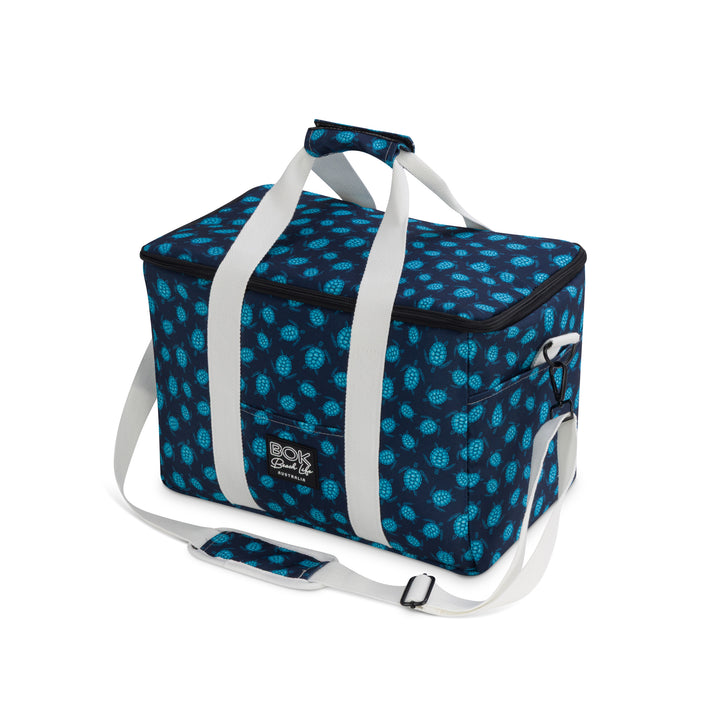 Blue  turtle patterned cooler bag with white straps on a white background