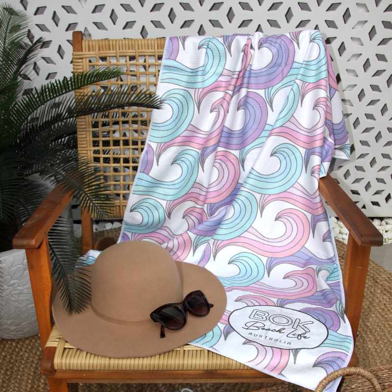 Bok Barrels microfibre sand beach towel featured on a rattan chair.