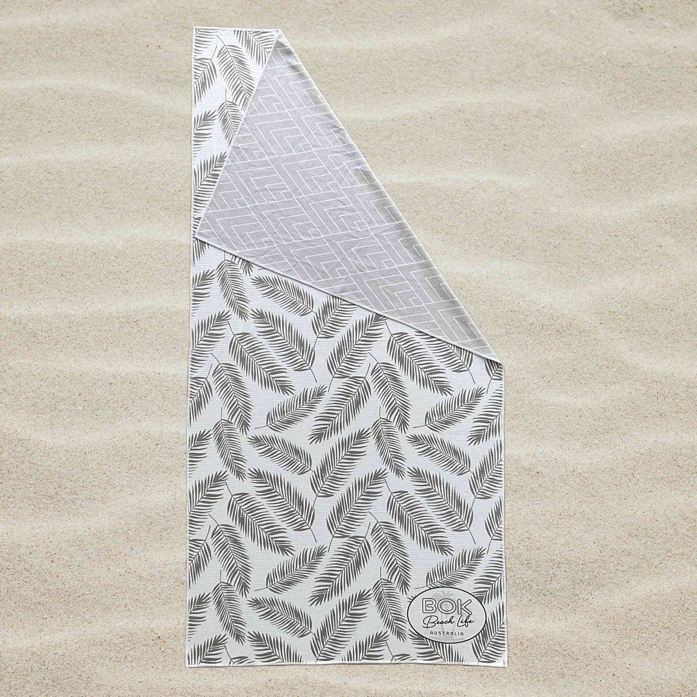 Coastal Luxe Sand Free Towel. Towel is 160cm x 80cm. Reversible 2 sided feather and chevron design in black white and grey.