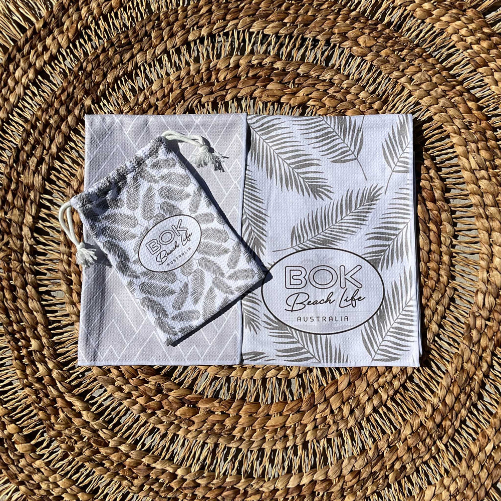 Coastal Luxe Sand free beach towel showing reversible design and handy carry bag.